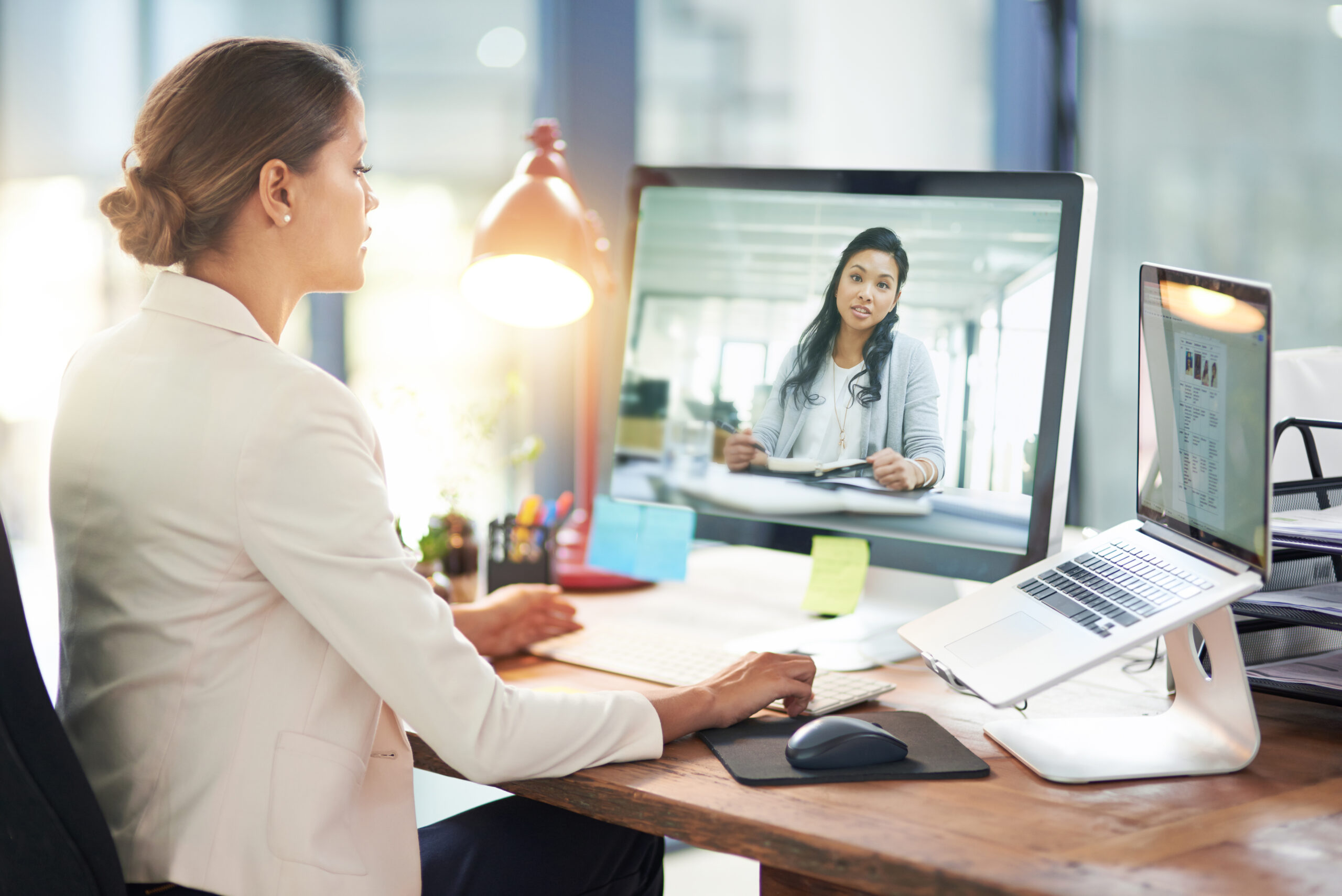 Shot of two colleagues video chatting with each other on a computer at work